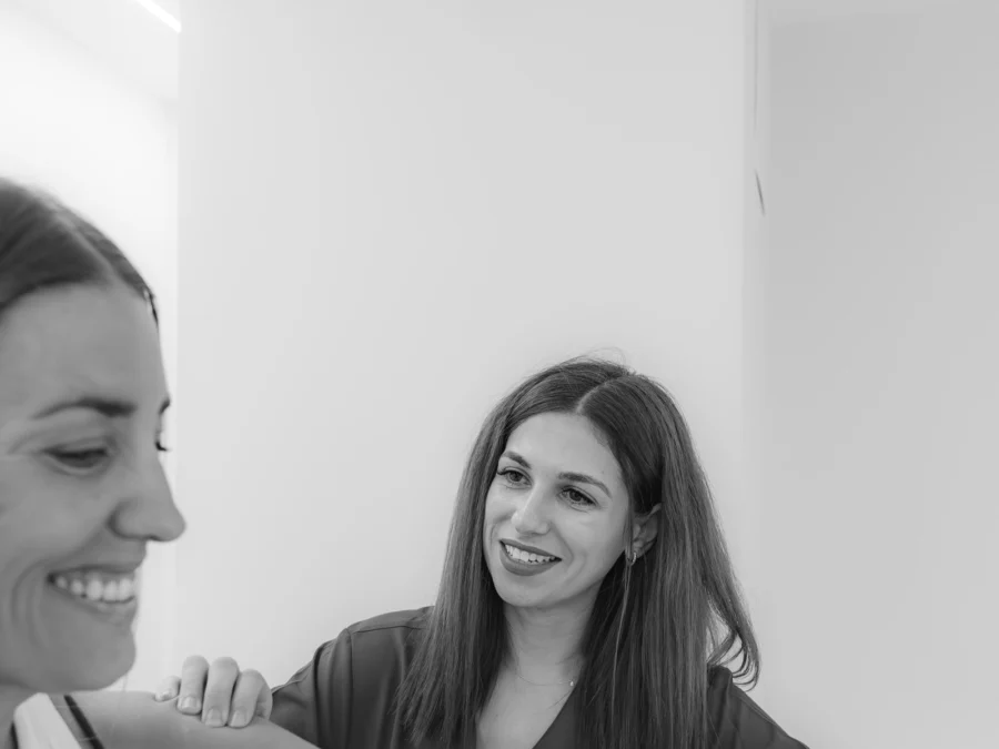 Fisioterapeuta guiando un ejercicio de hombro, en blanco y negro