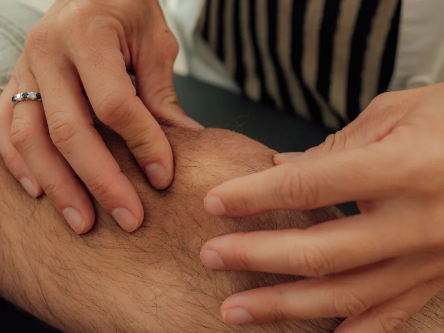 Exploración manual de la rodilla de un paciente