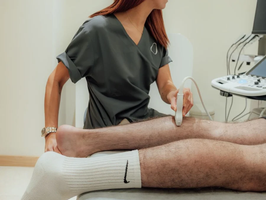 Fisioterapeuta explorando la pierna de un paciente con el ecógrafo