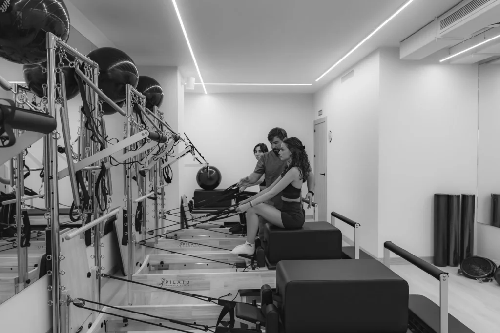 Alumnas en una clase de pilates reformer, en blanco y negro