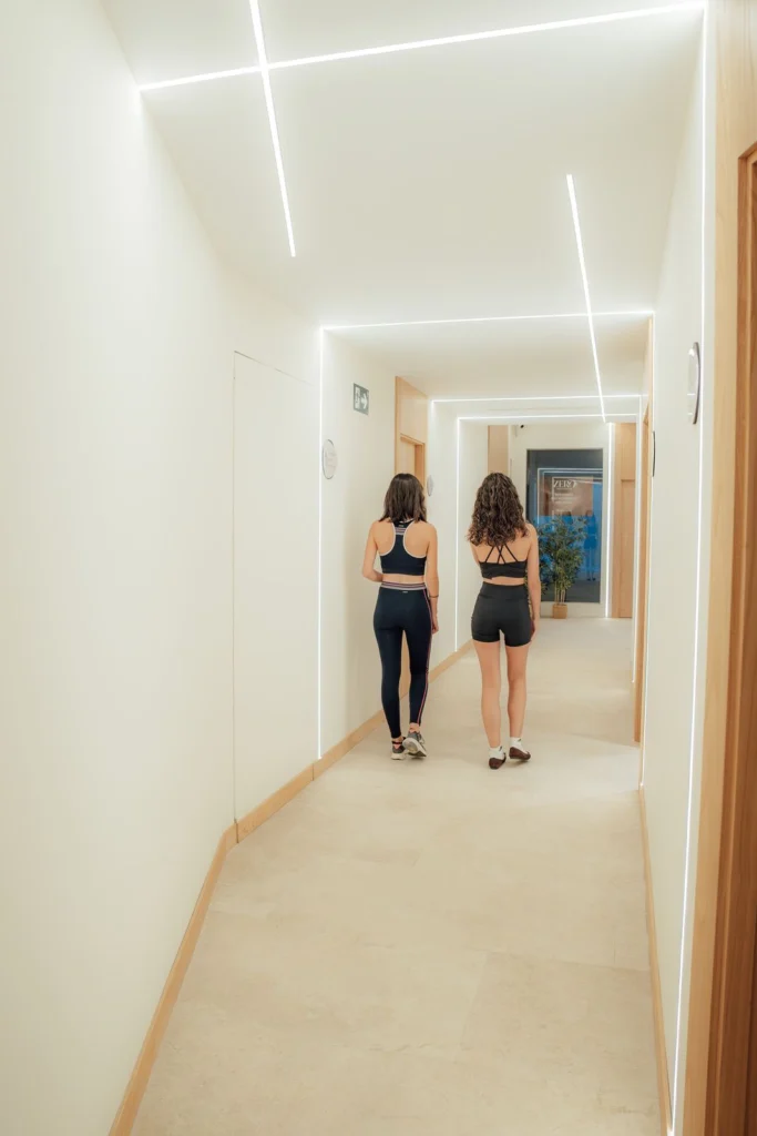 Pacientes en ropa deportiva caminando hacia su sesión de readaptación